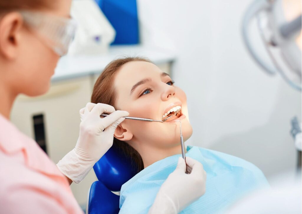 Dentist examining a patient’s teeth during a consultation about nightguards for teeth grinding and protecting enamel from wear.